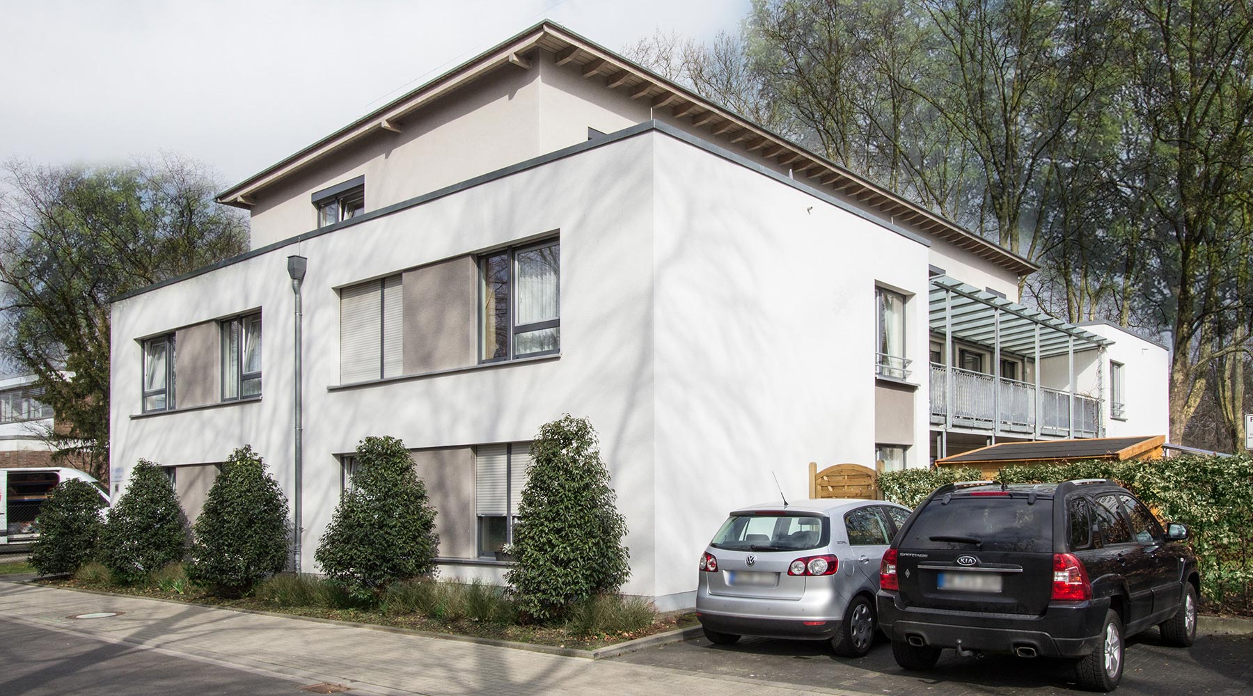 Haus Robert in Grevenbroich. Weiße Fassade mit grauen Akzenten zwischen den Fenstern.