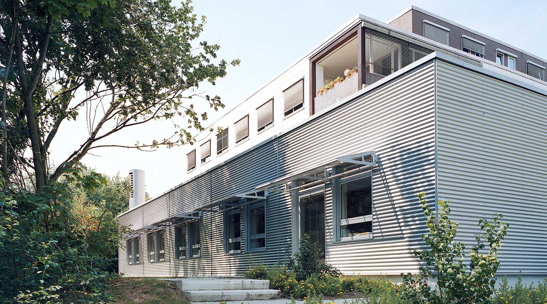 Moderne Architektur einer Intensivstation mit Aluminiumfassade angrenzend an Grünfläche.
